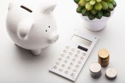 Image of piggy bank and calculator on a flat surface